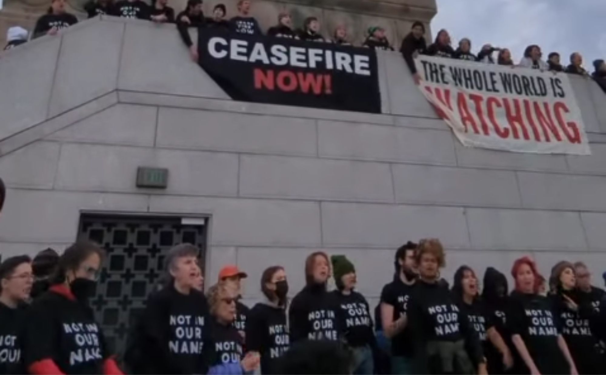 protestujący ludzie w czarnych koszulkach z napisem "nie w naszym imieniu"