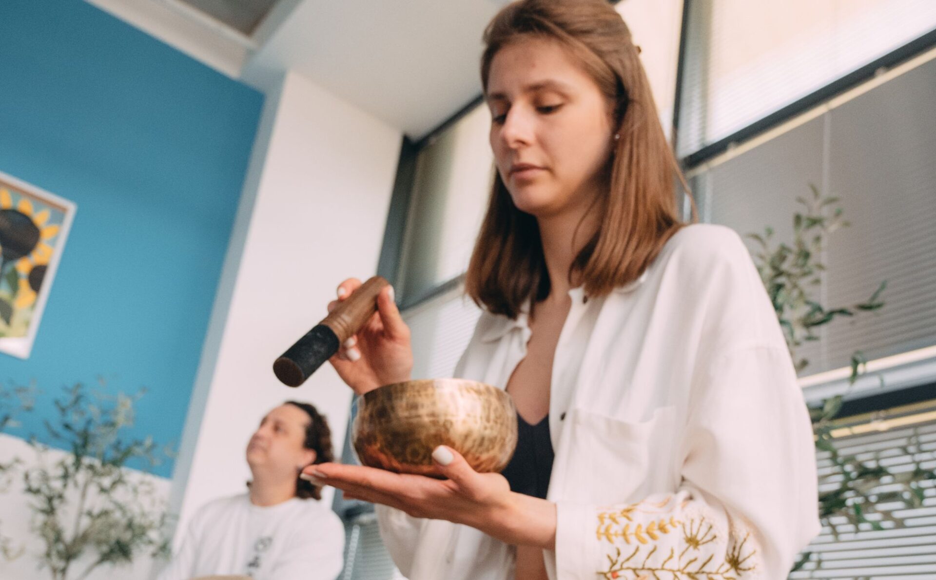 młoda kobieta gra na leczniczych misach gongi