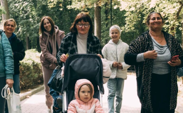 śmiejące się kobiety z dziećmi w zielonym parku