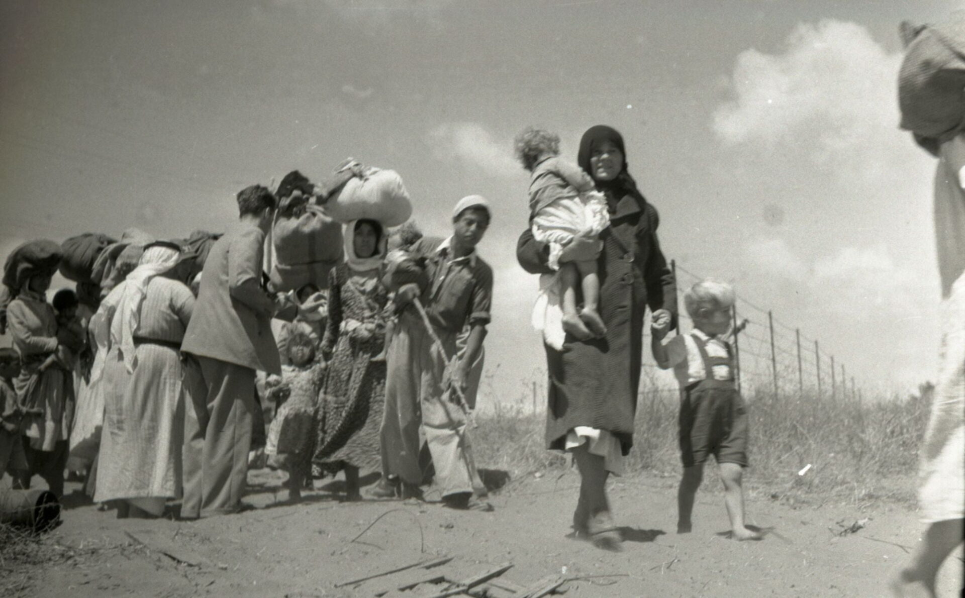 Grupa Palestyńczyków z bagażami opuszcza rodzinną wieś uchodźcy w latach 40. biało czarne zdjęcie