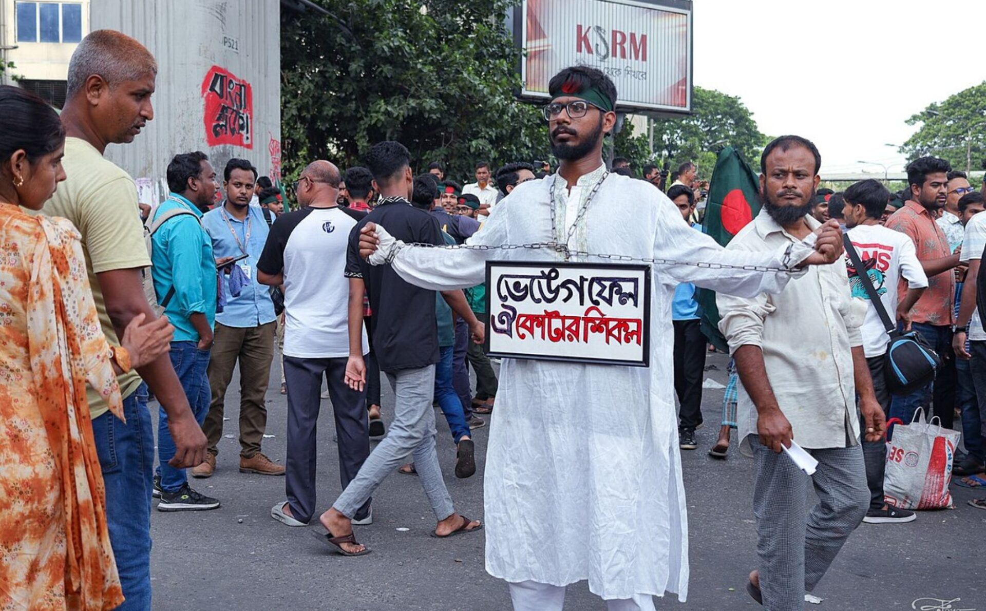 mężczyzna z transparentem, tłum ludzi protestujących