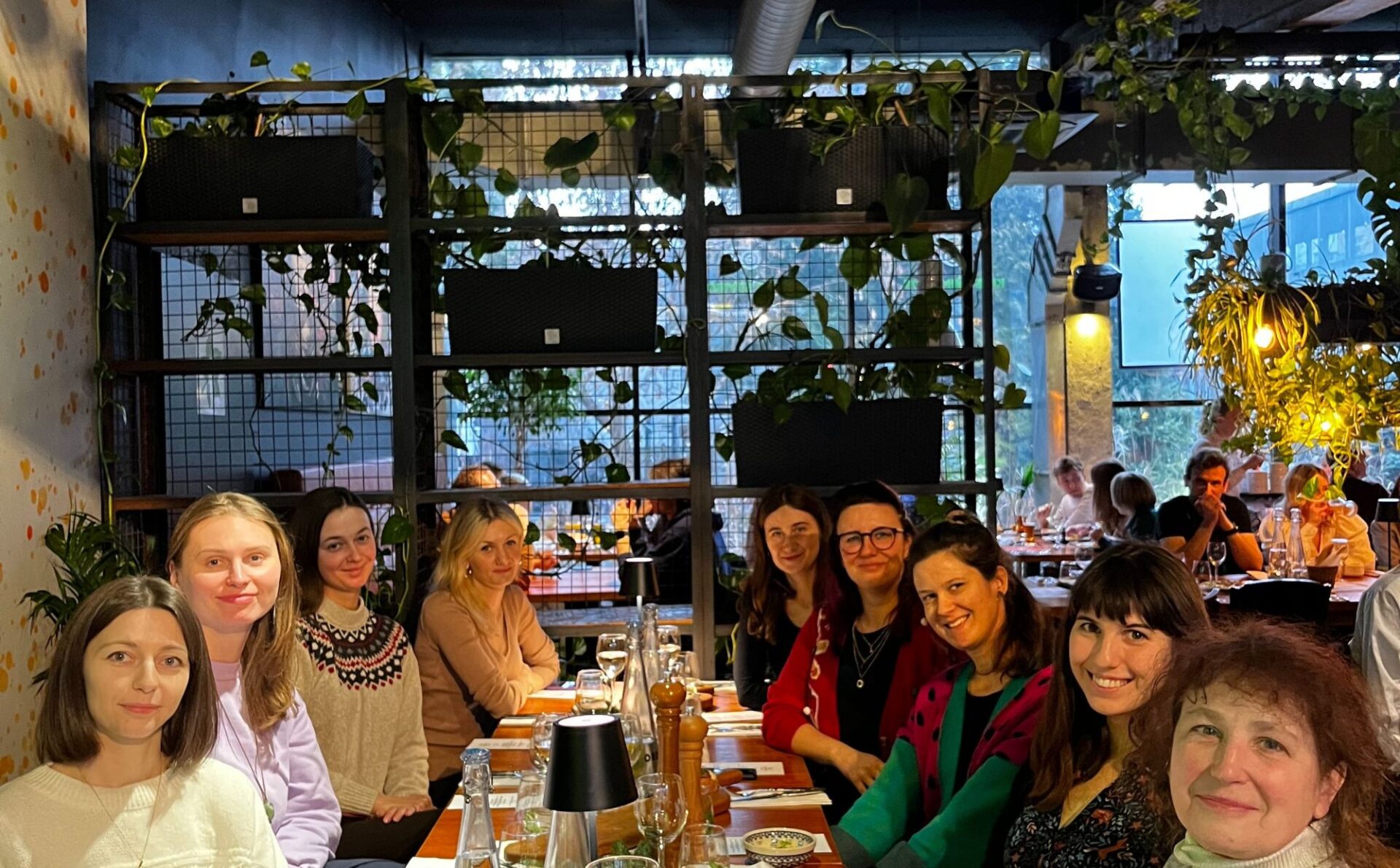 kobiety siedzące przy wigilijnym stole w restauracji, dużo roślin