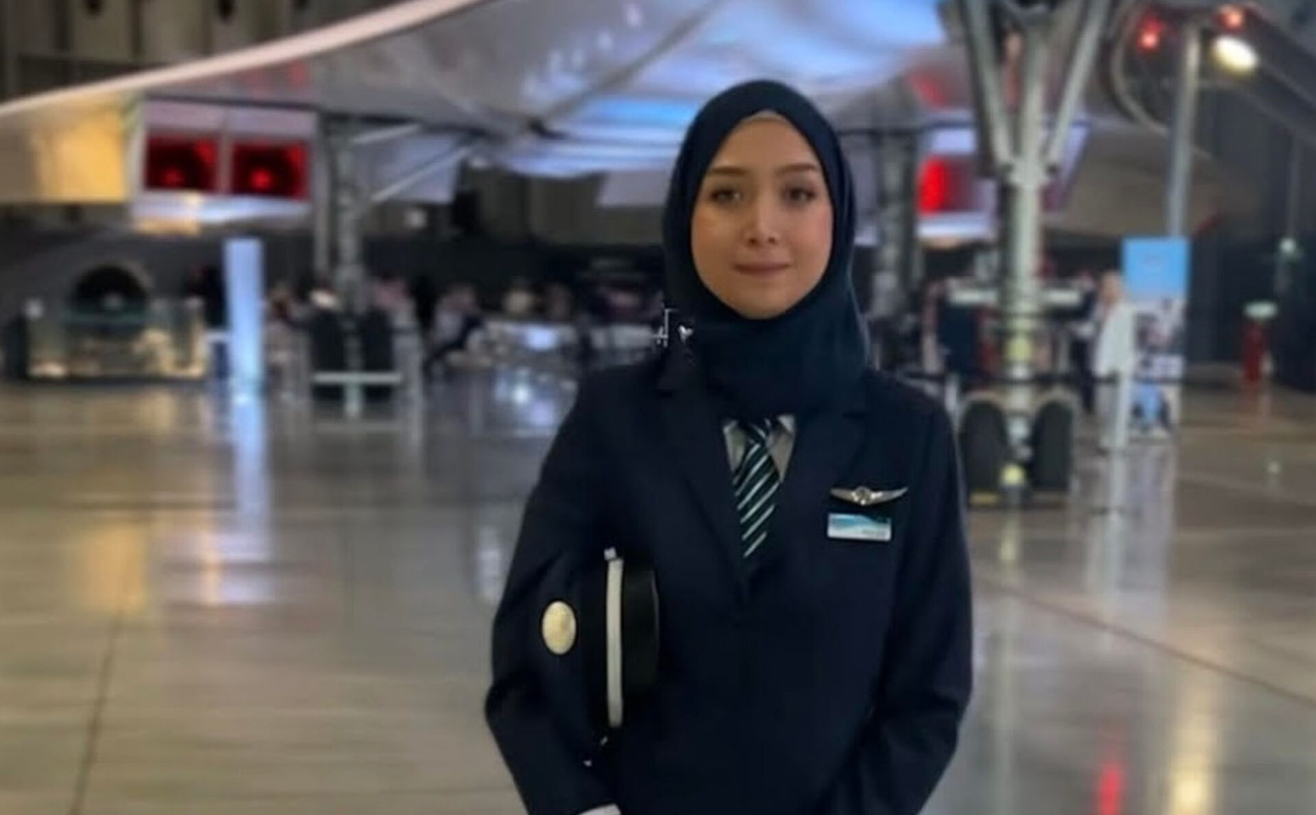 pilotka w hidżabie na lotnisku, w ciemnych ubraniach